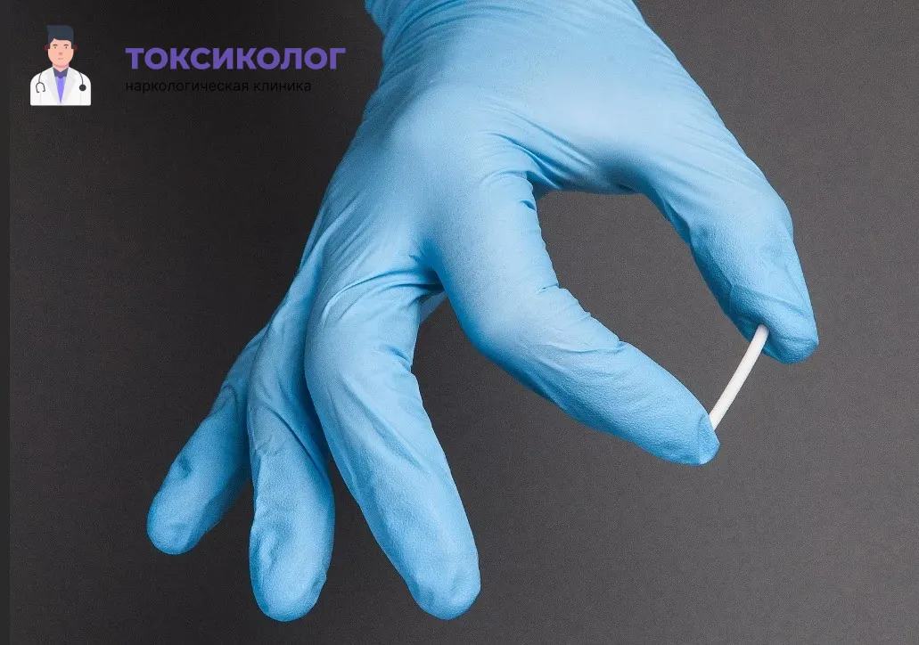 Препарат для кодирования методом вшивания ампулы. Подготовка стерильного импланта-капсулы для процедуры вшивания ампулы. Врач в голубой перчатке держит препарат.